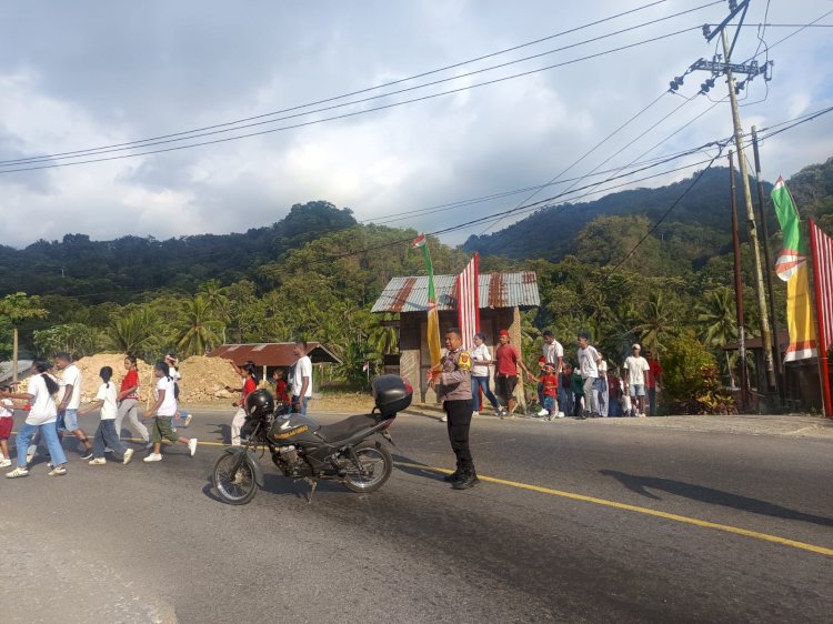Hadir di Tengah Warga, Bhabinkamtibmas Desa Roa Polsek Detusoko Kawal Kemeriahan Kirab Rakyat Desa Wolotolo